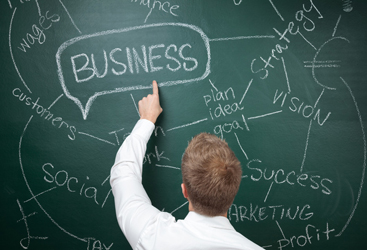 Man writing business ideas on chalk board